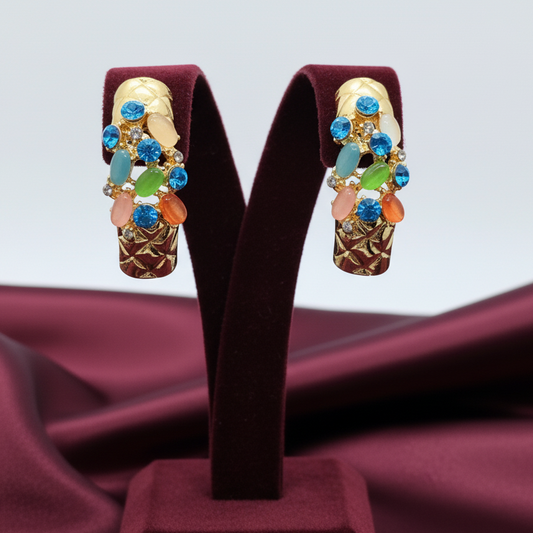 Colorful earrings on a dark brown earring stand with a plain background