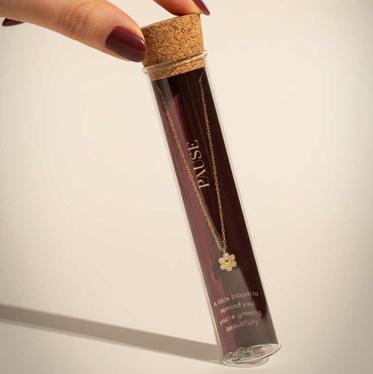 Hand holding a cylindrical product with cork lid against a neutral background